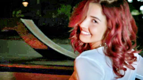 Agatha Da redhead smiling over shoulder in sheer white top