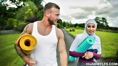 Muscular white guy and hijab-wearing German MILF walking outdoors with yoga mats