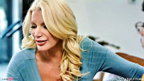 Blonde stepmom with big tits in blue cardigan, seductive expression