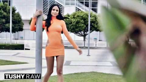 Ariana Marie in tight orange mini dress, flaunting curves outdoors