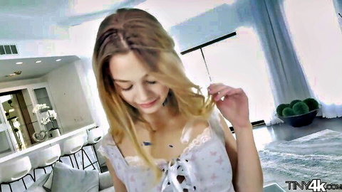 Young blonde babe in sheer lace top teasing with hair in luxury kitchen