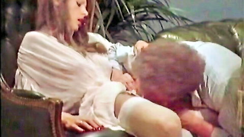 Woman in open white blouse breastfeeds red-haired man intimately