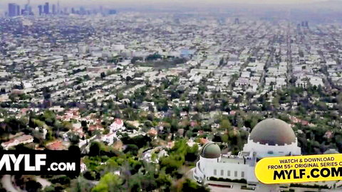 Aerial view of Los Angeles skyline at dusk with Griffith Observatory and MYLF.com watermark