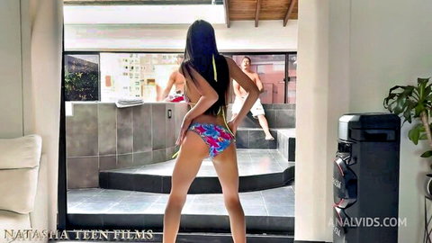 Hot teen in colorful bikini bends over showing juicy ass with stud watching by pool