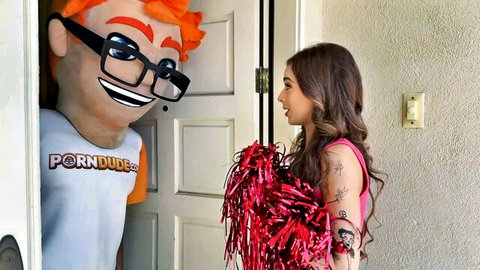 Brunette cheerleader in pink top with pom poms smiles at PornDude mascot in doorway