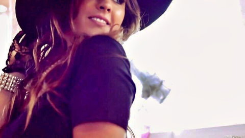Alice Lighthouse seductive close-up in hat and purple top, smiling alluringly