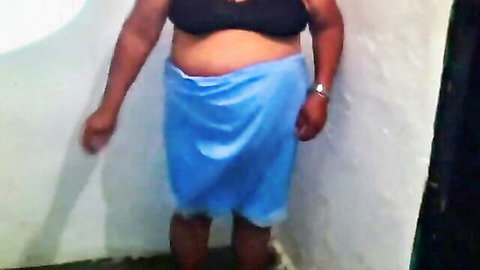Mature curvy woman in black bra and blue sarong, teasing with exposed skin