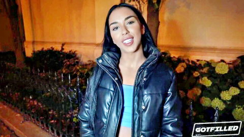 Young ebony babe smiling seductively in shiny blue puffer jacket teasing her tits outdoors