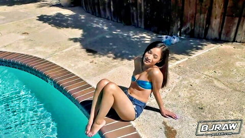 Avery Black in sexy blue bikini by pool, smiling seductively