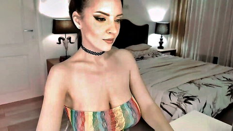 Fit busty model with massive tits spilling from colorful striped bandeau top in bedroom