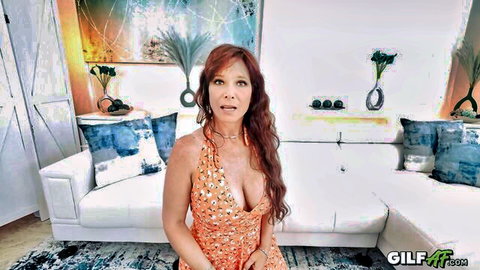 Sexy redhead GILF teases with deep cleavage in low-cut floral dress on couch