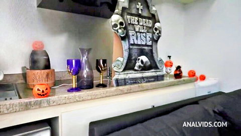 Halloween tombstone 'THE DEAD WILL RISE' decorations with pumpkins and fog on kitchen counter