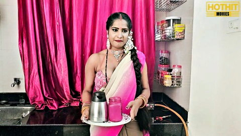 Sexy Indian babe in pink saree holds creamy milk glass teasing cleavage in kitchen
