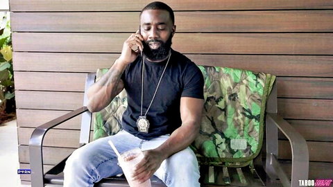 Muscular black man with beard on phone in casual outfit, TabooHeat BBC parody