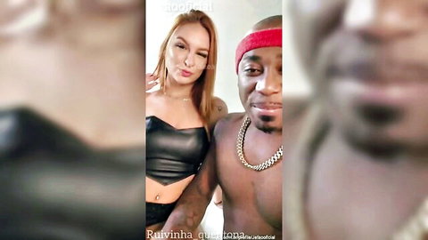 Busty Latina with big tits in black leather top poses intimately with shirtless muscular black guy