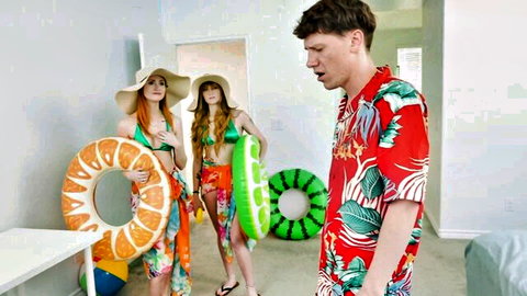 Two sexy redhead babes in skimpy bikinis hold pool floaties teasing guy in Hawaiian shirt