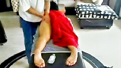 Masseur rubs exposed nude ass of Asian woman during erotic massage on table