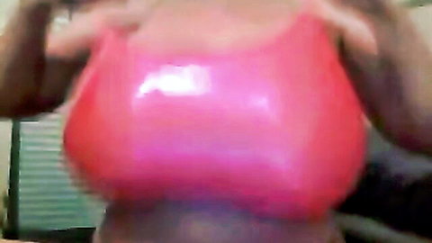 Ebony babe with massive tits in shiny pink top flaunting cleavage