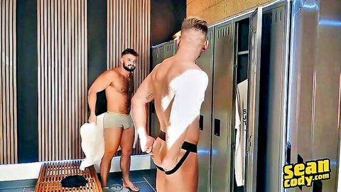 Muscular blond hunk bends over exposing big bare ass in locker room as bearded stud watches