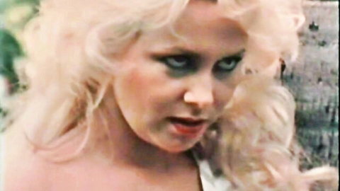 Vintage blonde mature woman with wild green eyes and parted lips in intense close-up