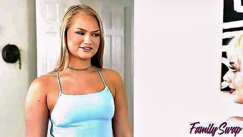 Blonde babe in tight blue tank top smiles teasingly with huge tits bulging out
