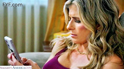Blonde MILF Cory Chase in purple top, engrossed in phone