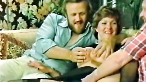 Vintage threesome with smiling brunette woman touched intimately by two bearded men