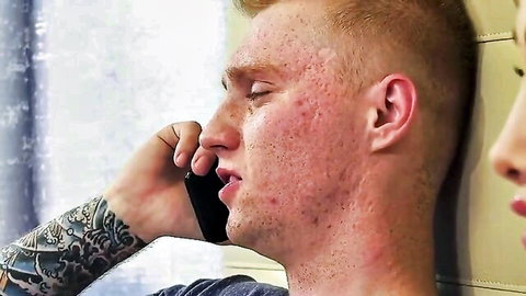 Blonde inked TS babe with tattoos on phone, intense gaze