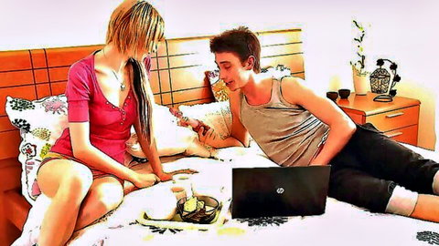 Blonde teen in pink tank top showing deep cleavage sits on bed watching laptop with boyfriend