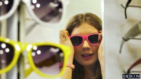 Elena Koshka, seductive Russian brunette, trying on pink sunglasses in teasing display