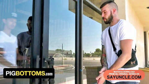 Muscular tattooed bearded hunk in white tee flirts with cap-wearing stud through gym glass door