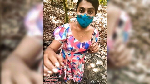 Sexy Indian woman Jayalakshmi in colorful short dress posing selfie in forest with blue mask
