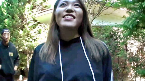 Smiling Asian onsen girl in black hoodie with guy outdoors, kinky hot spring tease