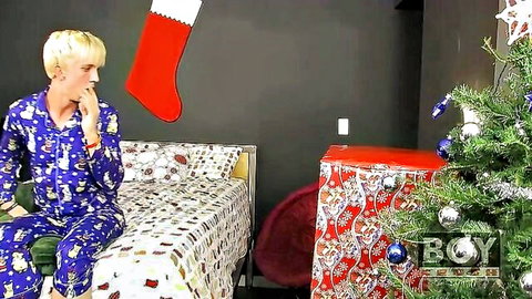 Jordan Ashton in blue Christmas pajamas on bed, holiday tease