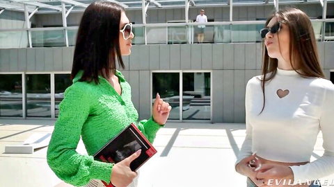 Brunette Alice in green dress chats poolside with friend, Evil Angel tease
