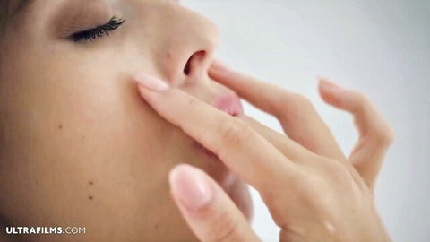 Young Asian beauty sensually sucks her fingers teasing her wet lips closeup