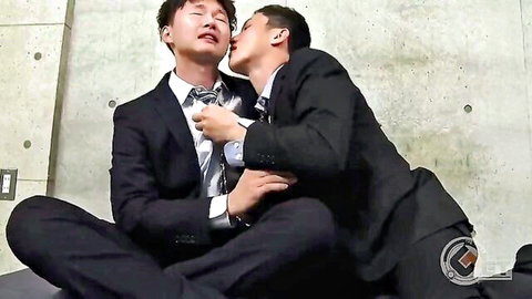Suited Asian men passionately kissing in kinky gay embrace