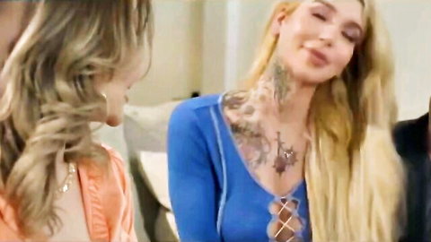 Tattooed blonde Gracie Jane in blue lace dress with cleavage, chatting with friend