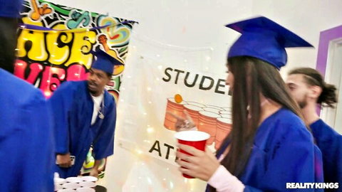 Young grads in caps and gowns partying wild at student fuck fest holding red solo cups