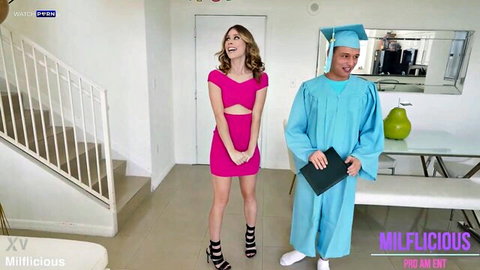 Blonde MILF in tight pink dress poses seductively with young graduate in cap and gown for taboo celebration