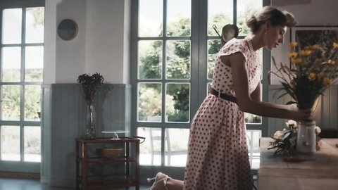 Fanta Sie in pink polka dot dress kneeling with flowers