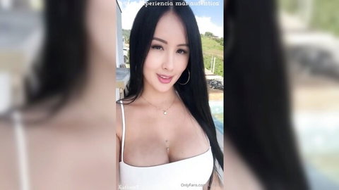 Sky Bri in low-cut white top showing cleavage outdoors