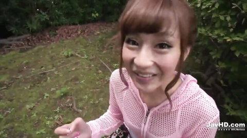 Sultry mature Asian babe in pink mesh top smiling outdoors seductively