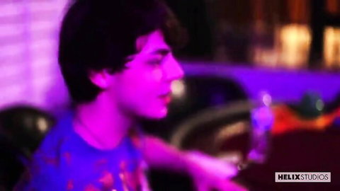 Handsome curly-haired twink in blue shirt at casino table, seductive gaze