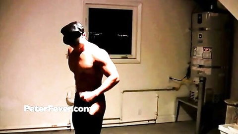 Blindfolded muscular gay hunk flexing ripped biceps and abs shirtless in basement