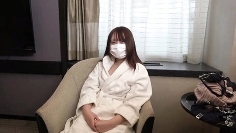 Hot Asian babe in robe smiling seductively behind mask