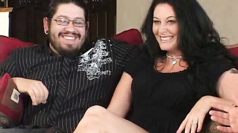 Curvy brunette MILF in black dress with smiling husband
