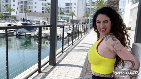 Arabelle Raphael busty brunette in sexy yellow top smiling outdoors