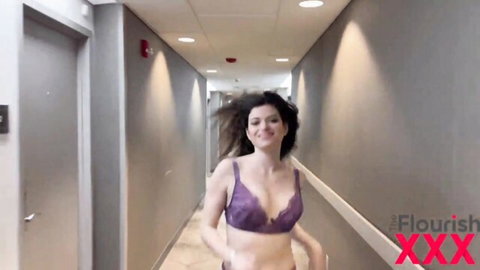 Brunette Nicole Rae in purple lacy bra teasing in hallway