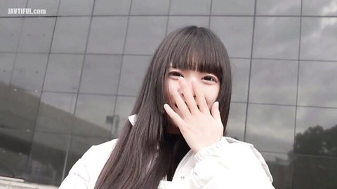 Cute Asian teen babe shyly covering mouth with hand in sexy white jacket outdoors teasing
